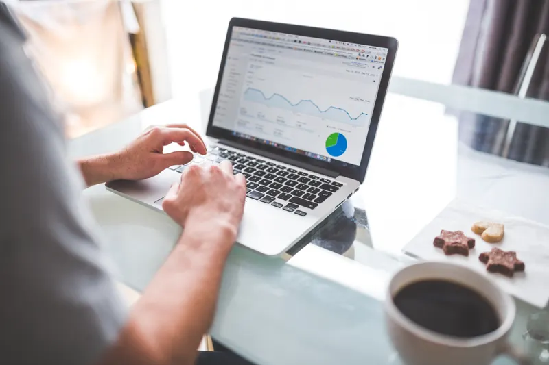 Hands on a keyboard beside an analytics dashboard