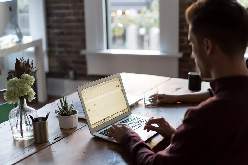 Person working at a laptop in a warm modern office